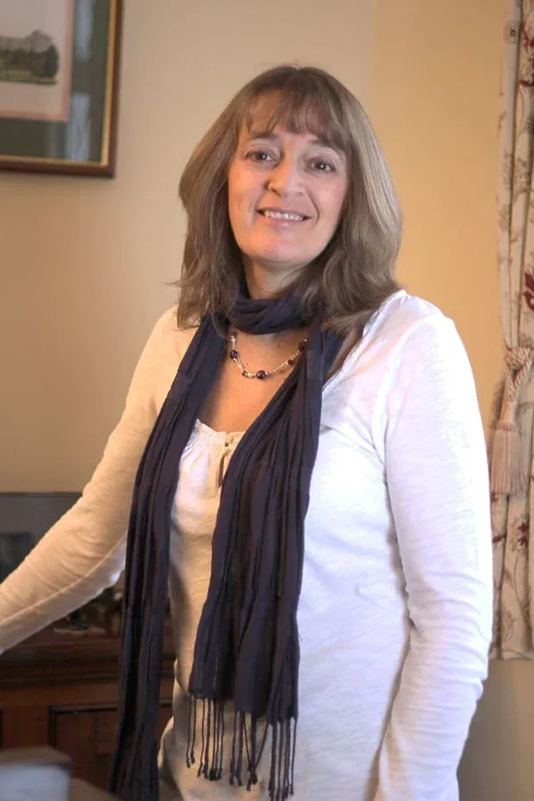 Alison Ling standing beside a piano in her teaching room